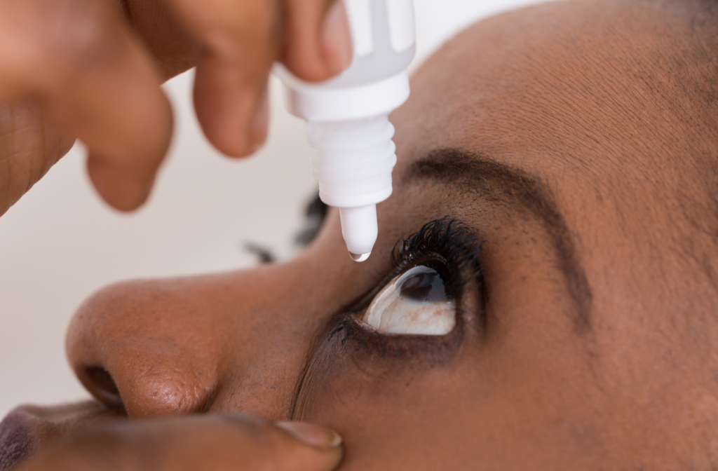 Woman putting artificial tears in her eyes with dropper